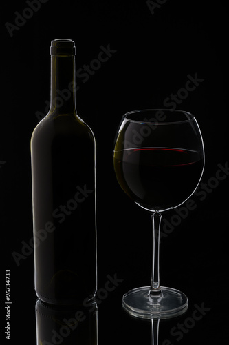 Glass of red wine with bottle