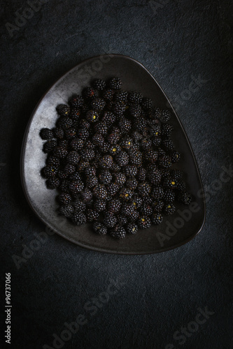 Tablou pe pânză Fresh blackberry on black plate.