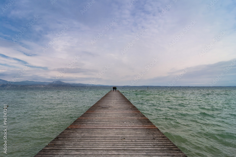 wooden pier and sky over Garda lake - Italy