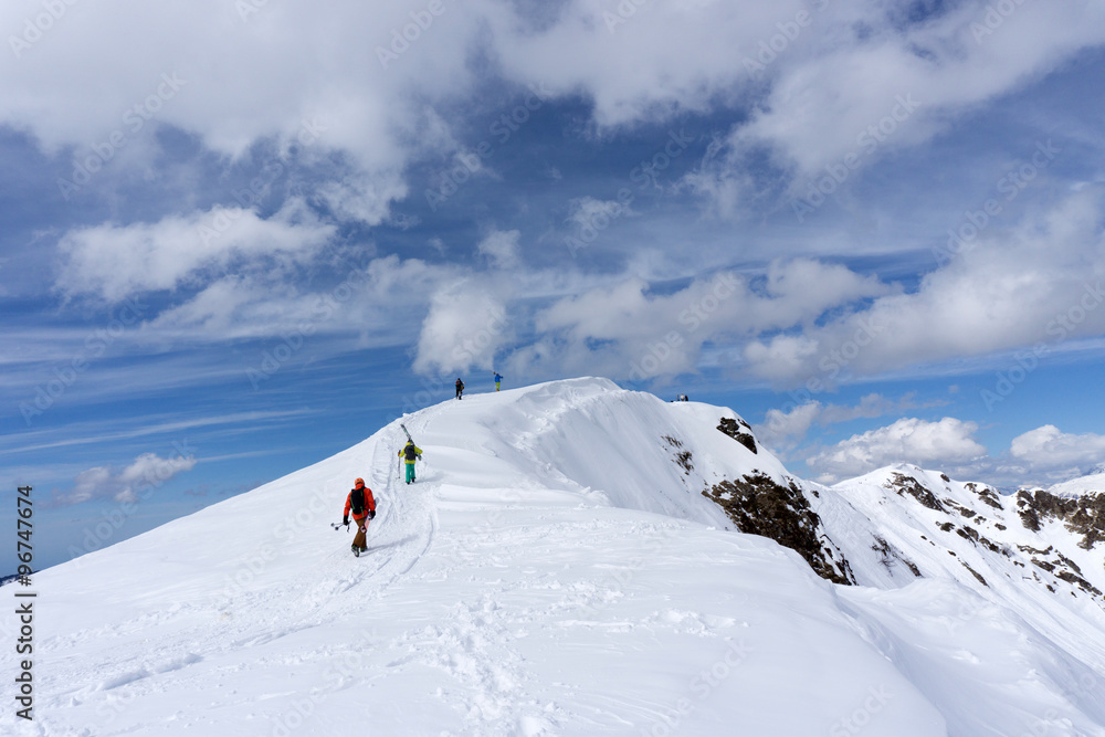 Skiers climbing a snowy mountain