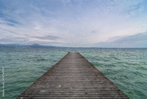 wooden pier and cloudy sky over Garda lake - Italy © eddygaleotti
