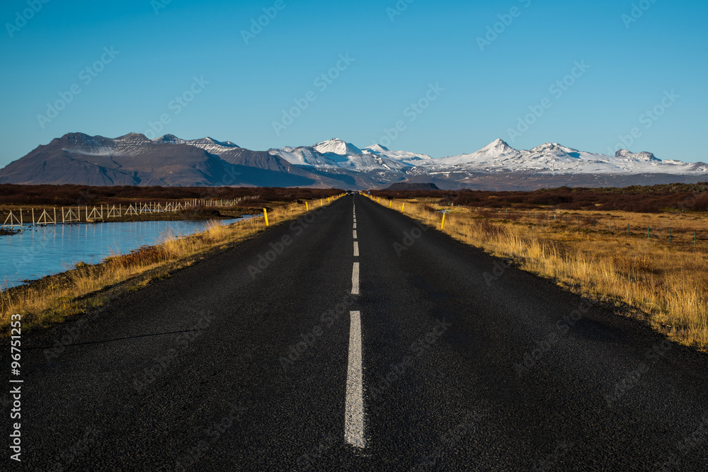 Highway Straight Road and snowcapped mountains