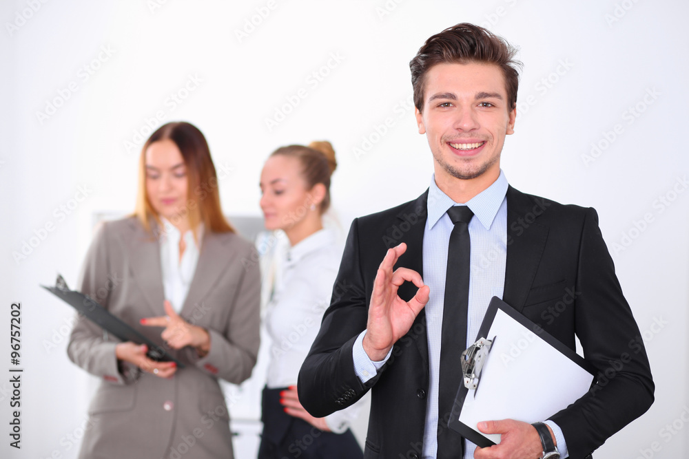 Cheerful business man in office with colleagues in the background, sturt up team Cheerful business man in office with colleagues in the background, sturt up team