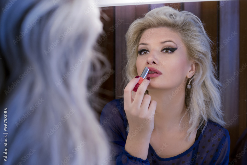 Beautiful girl putting lipstick on Beautiful girl putting lipstick on
