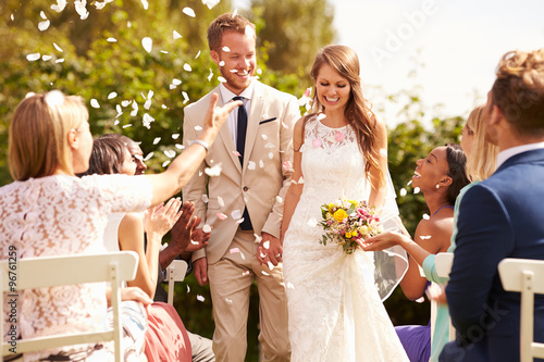 Canvas Print Guests Throwing Confetti Over Bride And Groom At Wedding