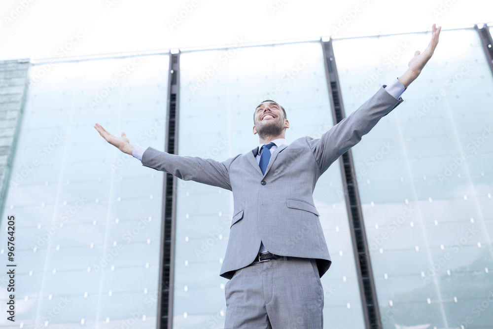 young smiling businessman over office building young smiling businessman over office building