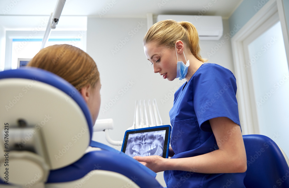 dentist showing x-ray on tablet pc to patient girl dentist showing x-ray on tablet pc to patient girl