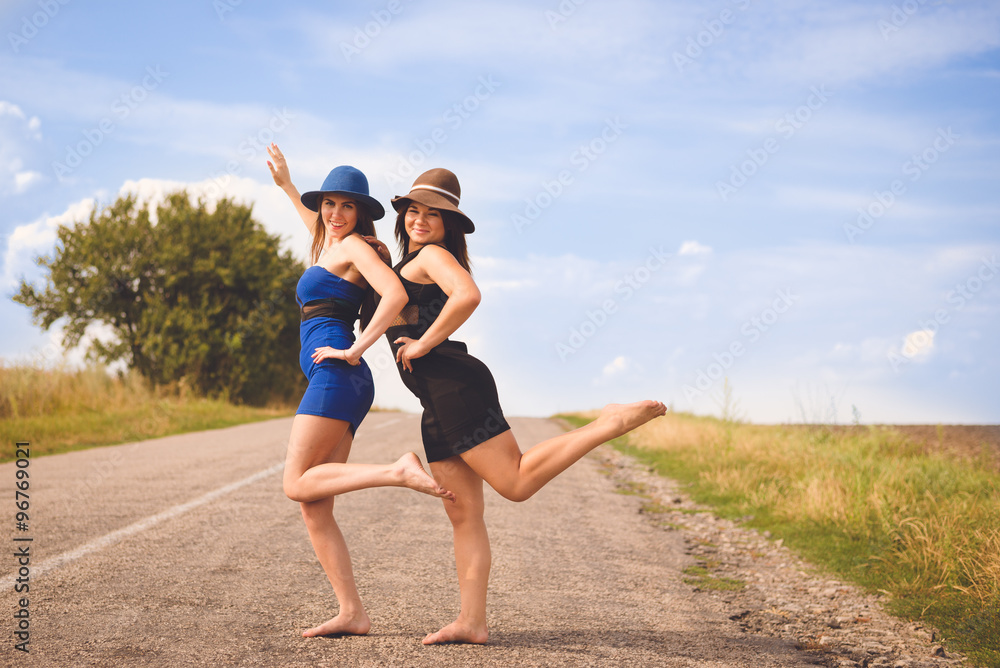 Picture of 2 pretty female having fun relaxing happy smiling, looking at camera on green summer outdoors background copy space Picture of 2 pretty female having fun relaxing happy smiling, looking at camera on green summer outdoors background copy space