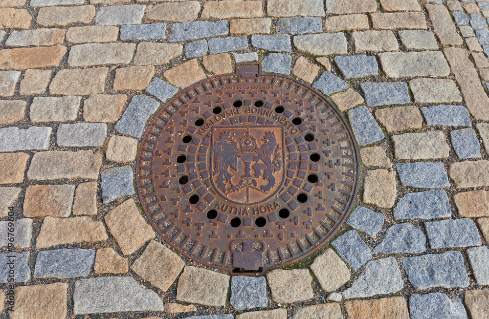 Sewer manhole with сoat of arms of Kutna Hora, Czech Republic