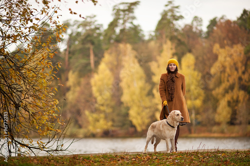 Красивая женщина гуляет в парке с собакой