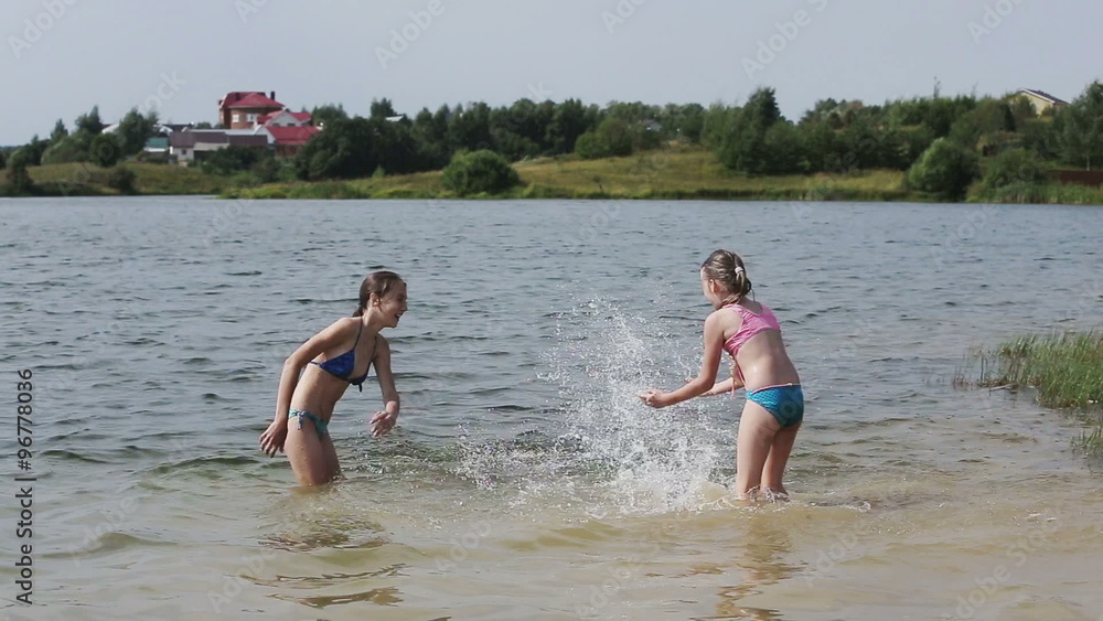Girsl splashing in the lake. Girsl splashing in the lake.