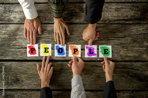 Fotografi Top view of six people assembling colourful word People