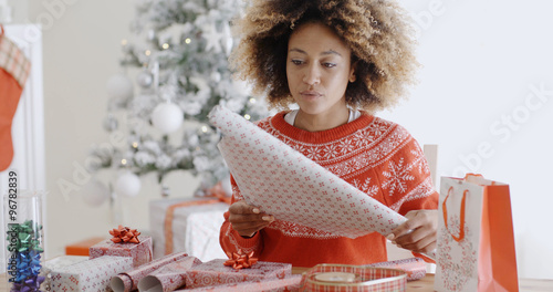 Happy young African woman wrapping presents