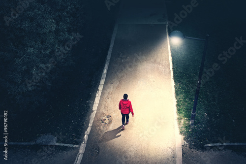 alone girl walking in the park in the night photo