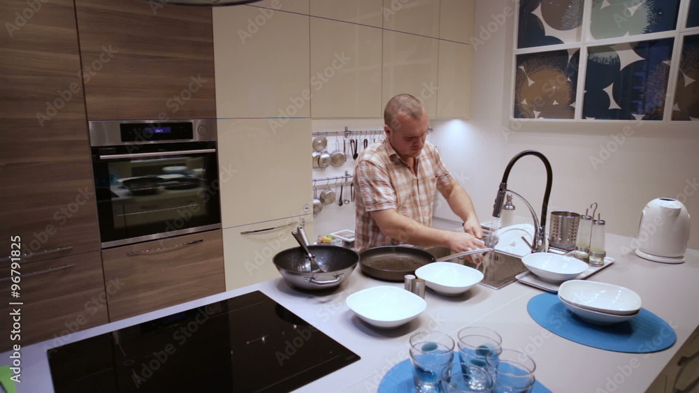 Man doing dishes after diner in the kitchen Man doing dishes after diner in the kitchen