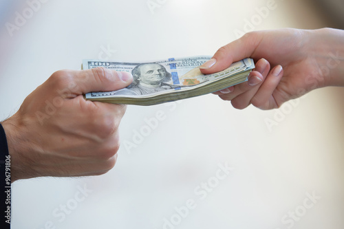 business woman and a businessman hold money