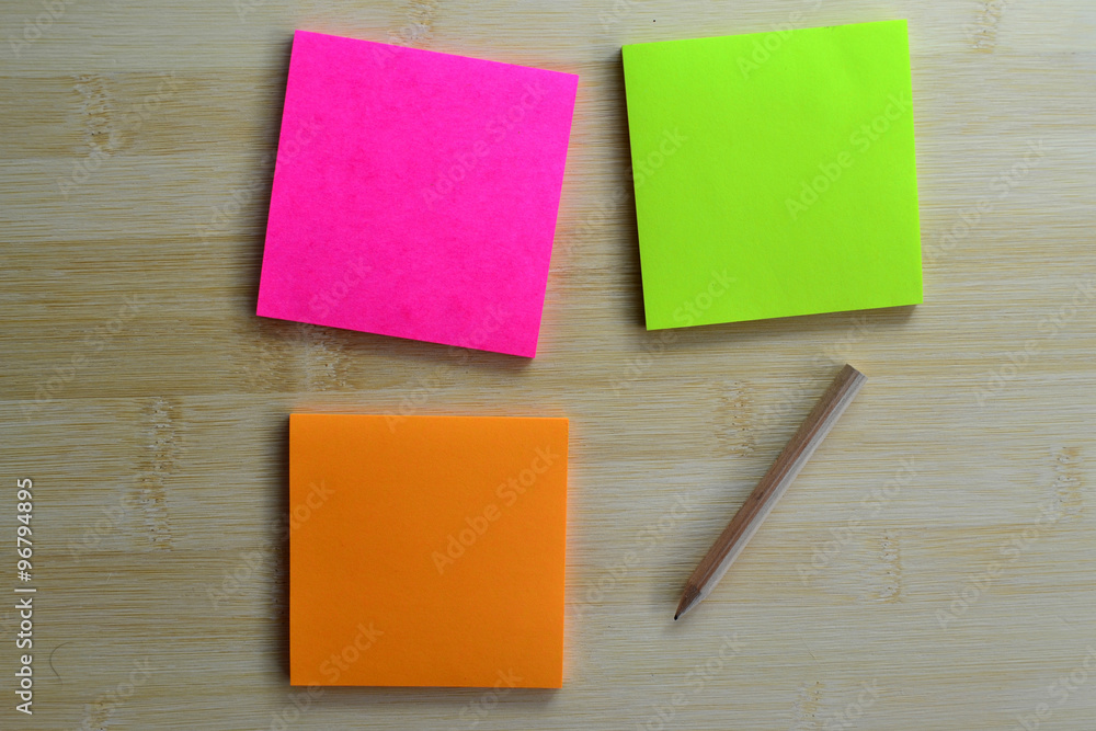 Colorful post it note and wooden pencil on wooden board Colorful post it note and wooden pencil on wooden board