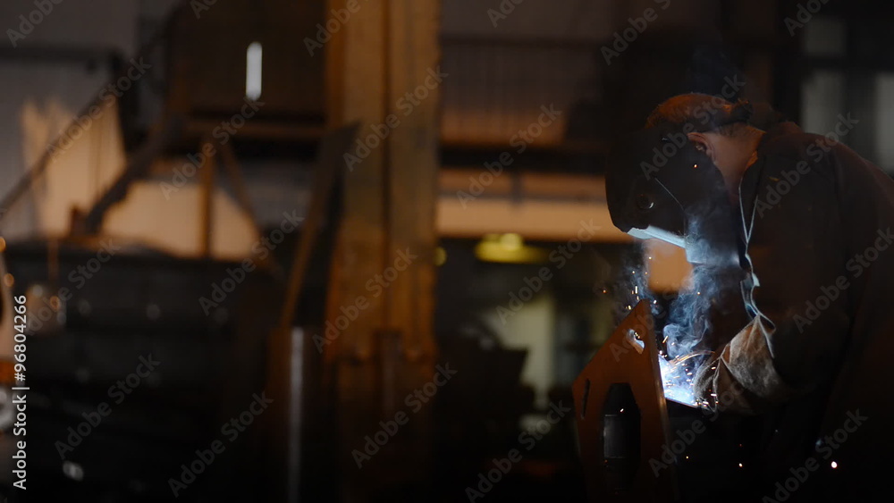 Welding Engineer weld attaching the base of pipes.a lot of bright sparks, smoke and light. Construction and manufacturing Welding Engineer weld attaching the base of pipes.a lot of bright sparks, smoke and light. Construction and manufacturing
