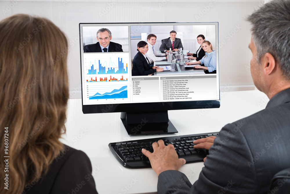 Two Businesspeople Participating In Video Conference Two Businesspeople Participating In Video Conference