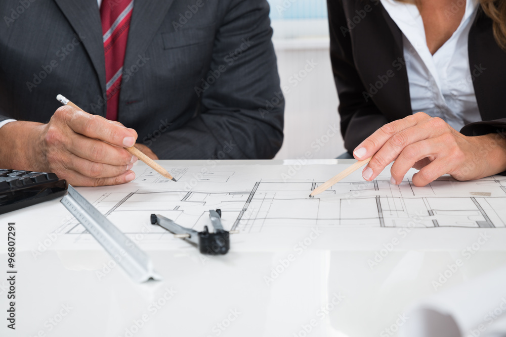 Two Architects Working On Blueprint Two Architects Working On Blueprint