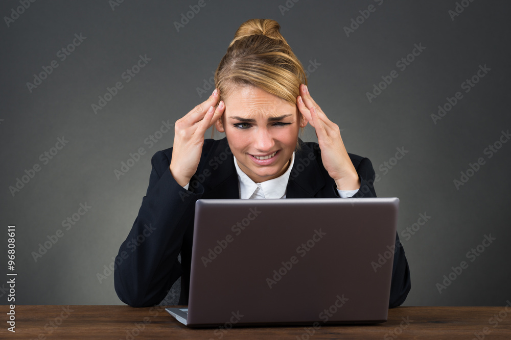 Businesswoman Suffering From Headache At Desk Businesswoman Suffering From Headache At Desk