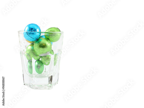 Chocolate Ball Wrap Up With Colorful Foil In Clear Glass Isolated On White Background