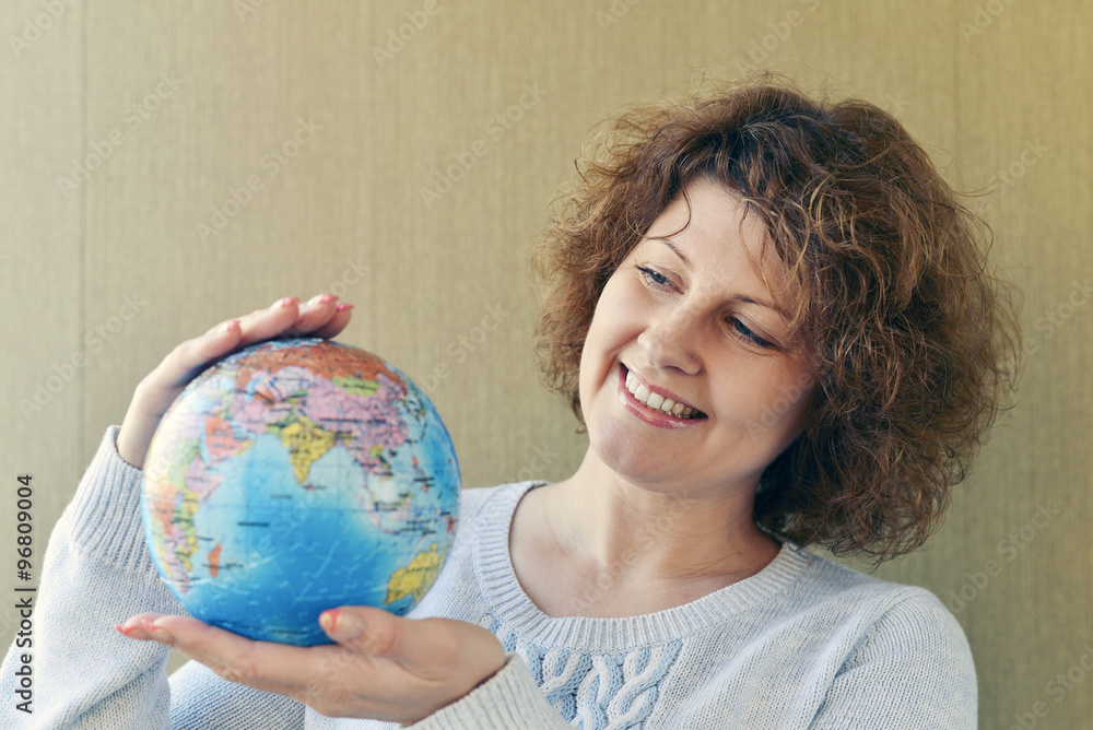 Woman with globe in hands thinking about traveling Woman with globe in hands thinking about traveling