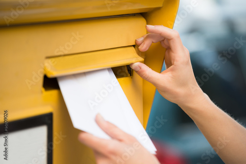 Woman's Hands Inserting Letter In Mailbox photo