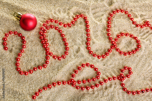 congratulations with new year and Christmas decorations on sea sand background