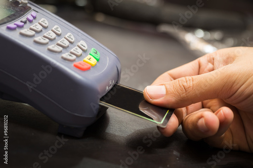 Close Up Of Hand With Credit Card Swipe Through Terminal For Sal