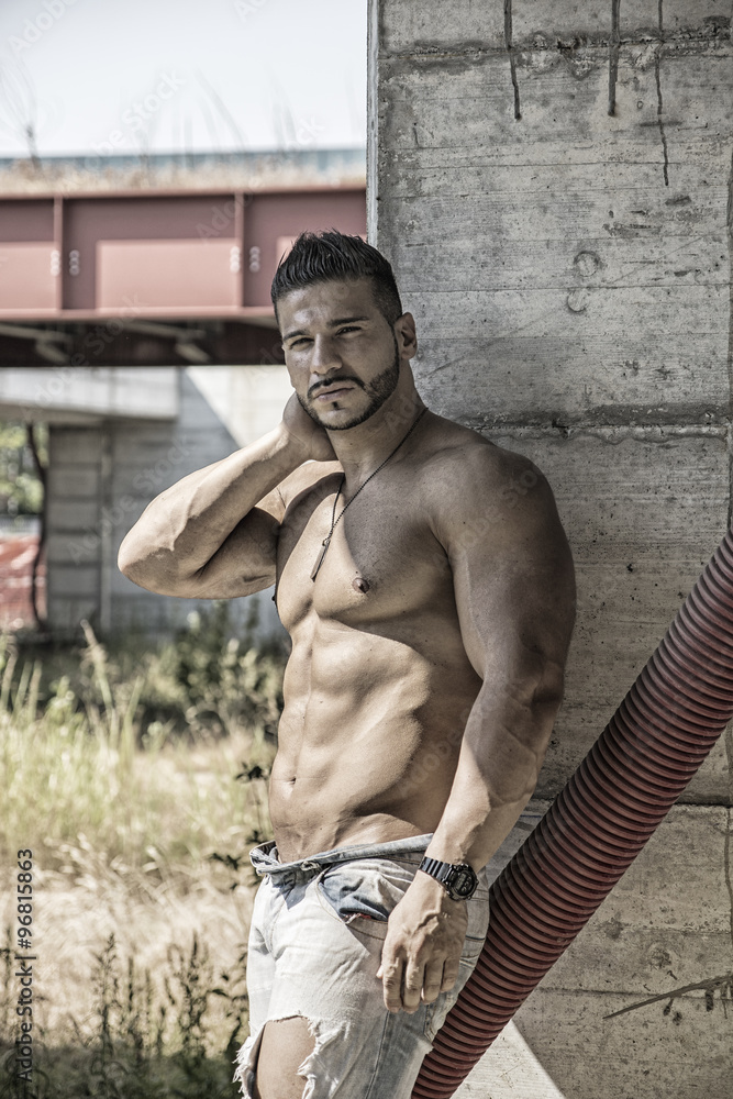 Muscular construction worker shirtless in building site Stock Photo