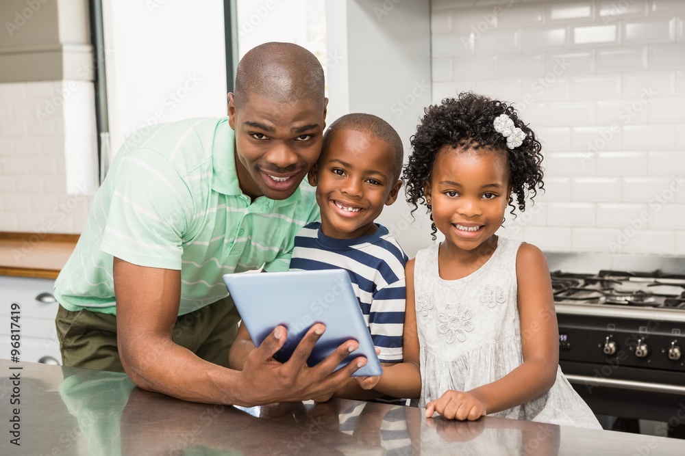 Father using tablet with his children in kitchen