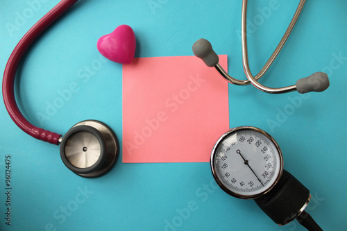Medicine concept - stethoscope and blood pressure equipment on blue background - copy space for text in the middle