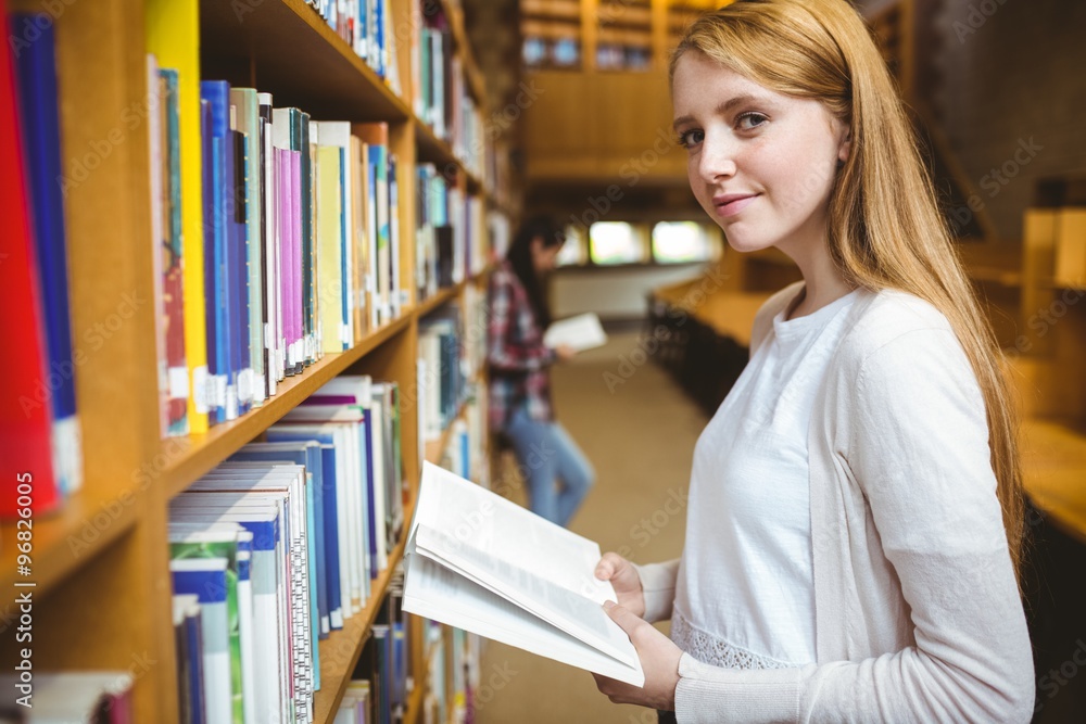 Blond student reading book in library Blond student reading book in library