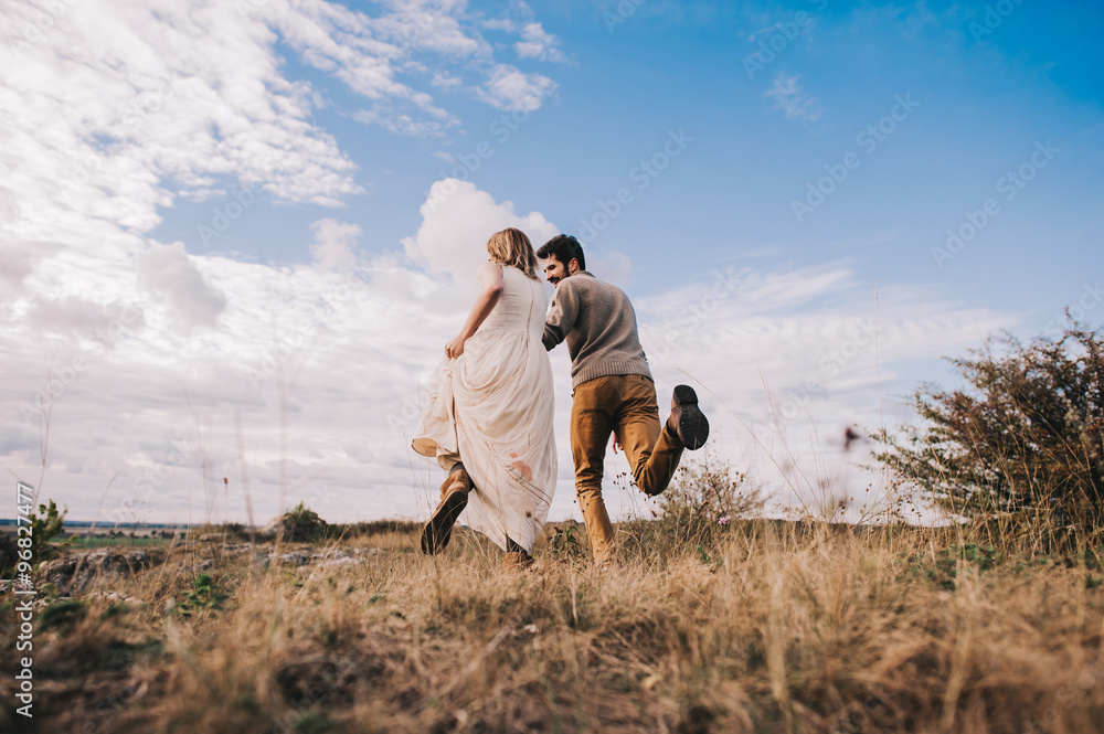 Fototapeta premium couple in the field near the mountains