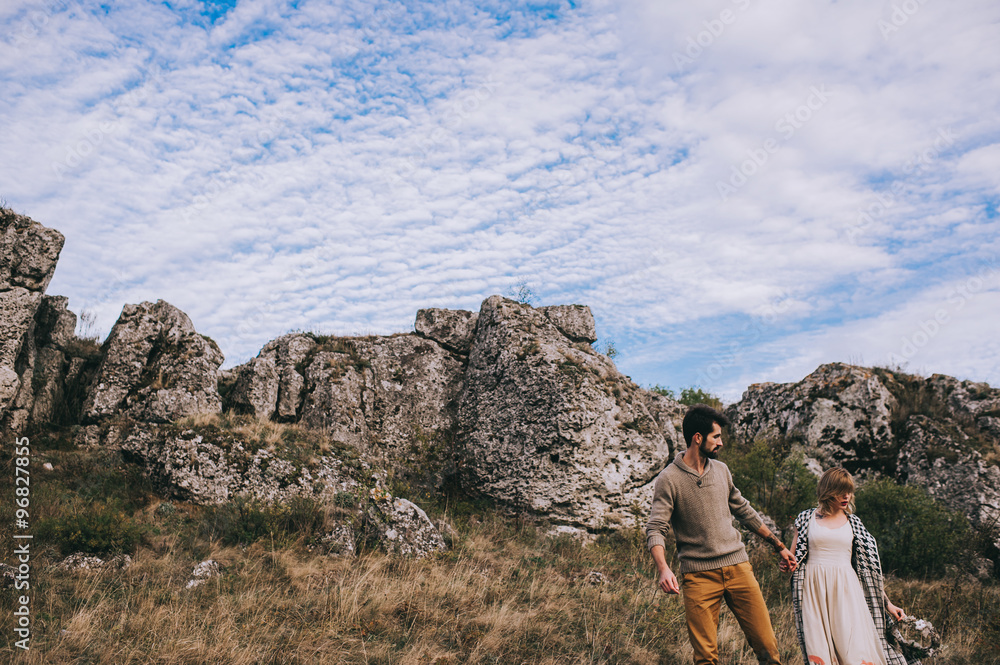 Fototapeta premium couple in the field near the mountains