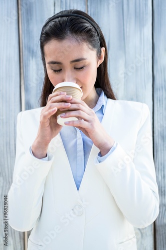 Smiling businesswoman with take-away coffee