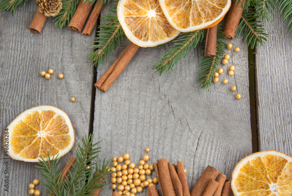 Traditional Christmas frame with spices, decorated with dried orange around central copyspace on a rustic wood background for your Christmas message. Traditional Christmas frame with spices, decorated with dried orange around central copyspace on a rustic wood background for your Christmas message.