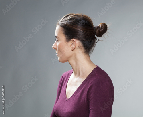 female portrait - thinking 30s woman with tied brown hair looking back for  questions and nostalgia on her past,profile view,studio shot Stock Photo |  Adobe Stock