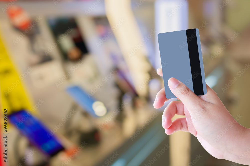 hand holding credit card in mobile phone store