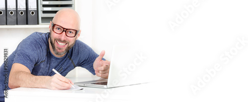 Mann notirer vor dem Computer