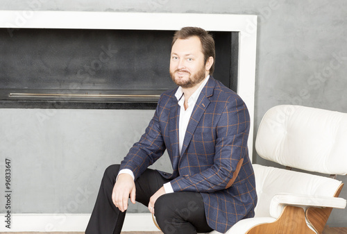 Portrait of a man sitting in a chair.