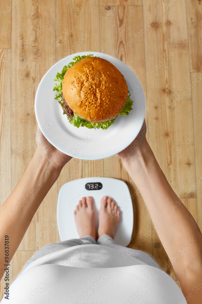 Diet And Fast Food Concept. Overweight Woman Standing On Weighing Scale