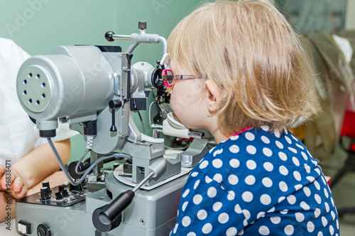 Optometrist with patient, giving an eye examination