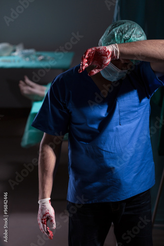 Exhausted doctor in sterile uniform