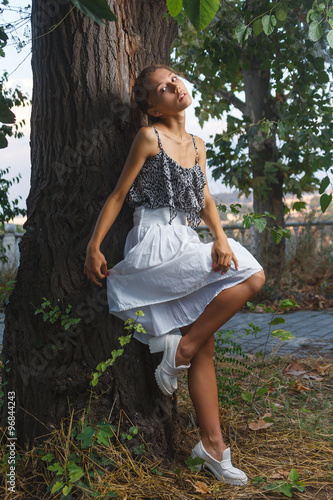 Fashion portrait shoot of beautiful teen girl posing near tree © Mrakor