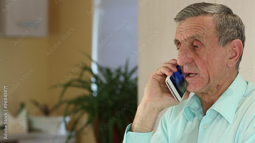 Senior man with white smartphone speaks. Man in blue shirt communicates via mobile phone
Senior man with white smartphone speaks. Man in blue shirt communicates via mobile phone