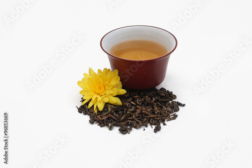 Керамический гайвань рядом с чайными листьями улун и желтой хризантемой photo