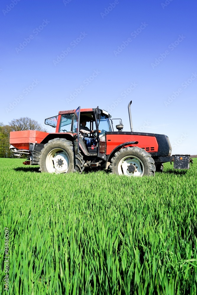 Landwirt beim verteilen des Mineraldüngers Landwirt beim verteilen des Mineraldüngers