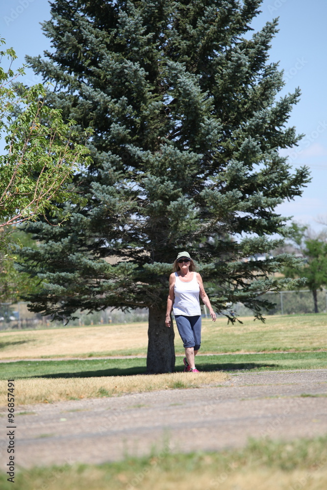Mature female beauty walking in the park outdoors. Mature female beauty walking in the park outdoors.